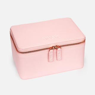 Pink hard storage case with closed rose gold zip and text that states "VUSH" against light grey background