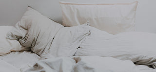 Close up of pillows on bed with off-white bed sheets