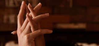 Two hands intertwined in room with intimate lighting