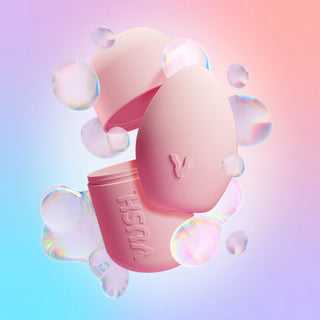 Plump palm vibrator and case in Pink Friday colourway displayed amongst digital iridescent bubbles against pink/blue/purple gradient background