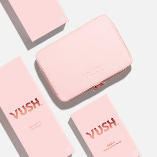 Bird's eye view of pink hard storage case with text that reads "VUSH" next to pink rectangular box that reads "VUSH Majesty 2 Wand Vibrator" above pink rectangular box that reads "VUSH Rose 2 Precision Bullet Vibrator"