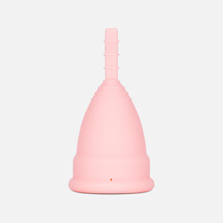 Upside down pink menstrual cup against light grey background